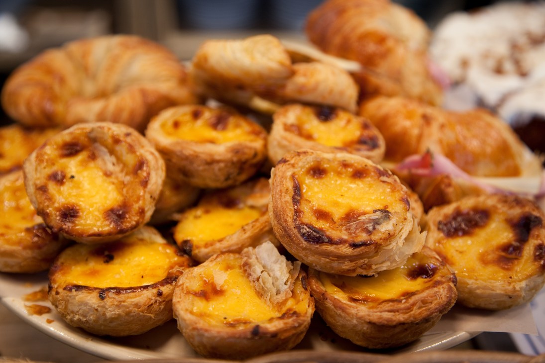 Pastéis de nata pastries with caramelised custard filling on a plate.