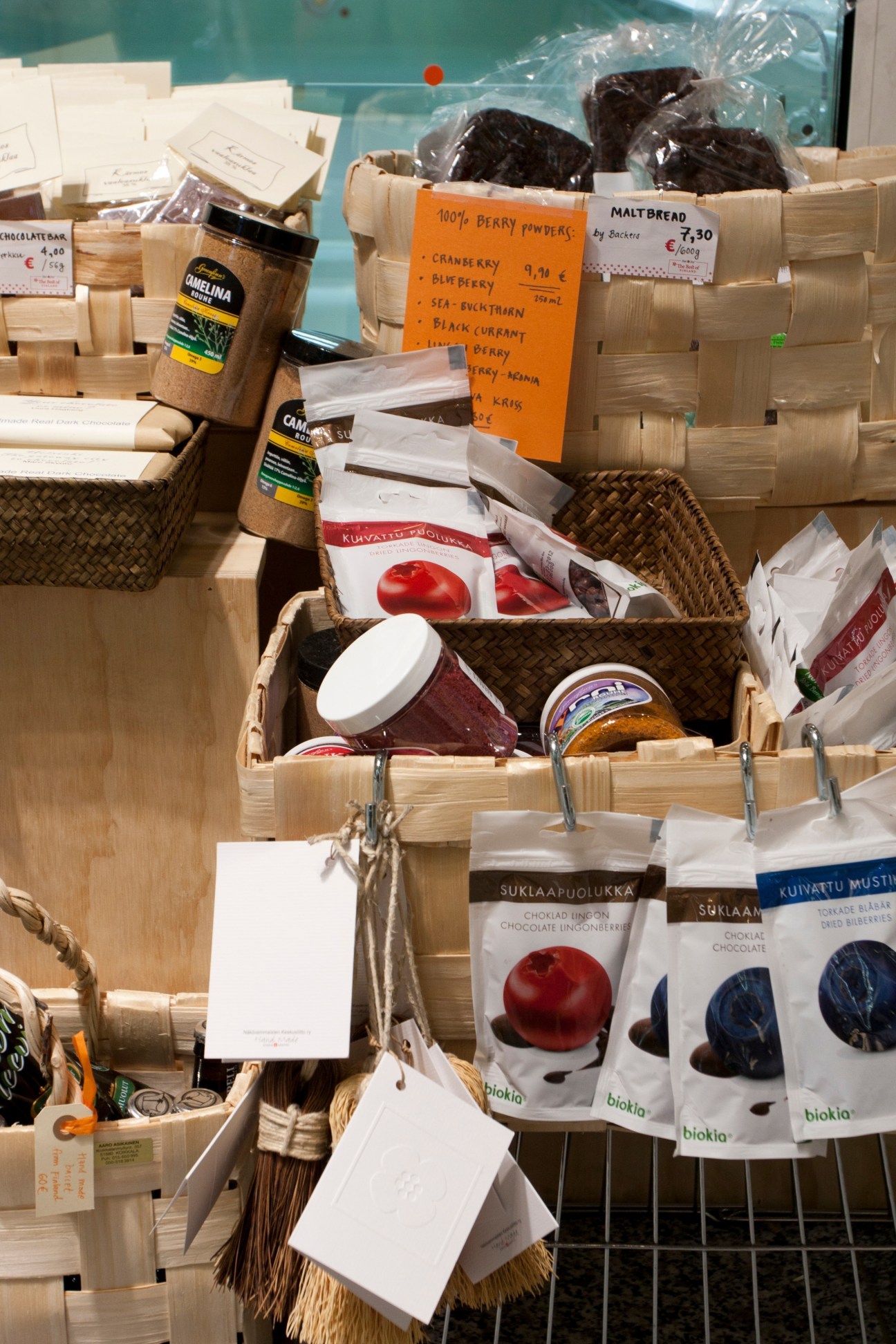 Display of Finnish food products in wooden baskets including berry powders, bread, chocolates and packaged goods at Best in Finland shop.