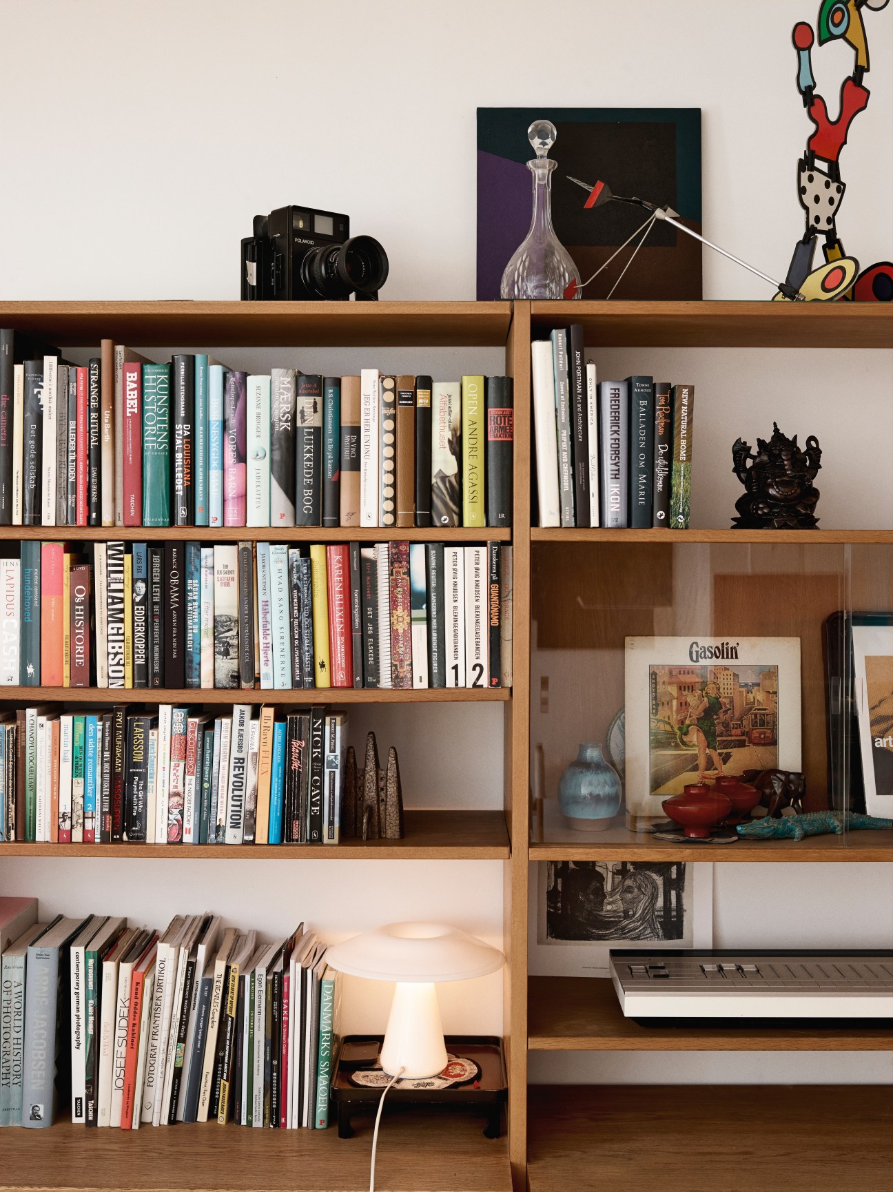 Hans J Wegner wall system with books, Polaroid camera, and vintage B&O Beocom 5500 sound system.