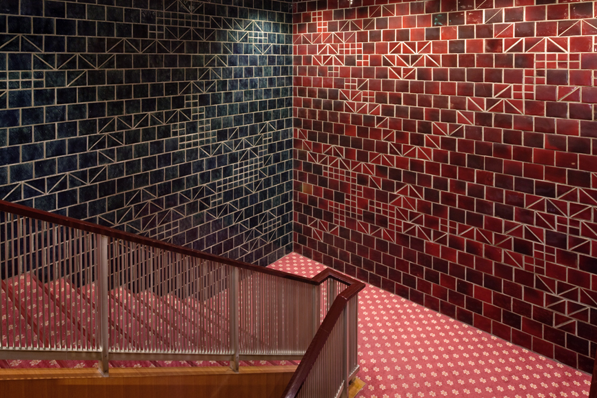 Decorative tiles on Hotel Okura staircase with geometric patterns in navy and red featuring traditional Japanese motifs.