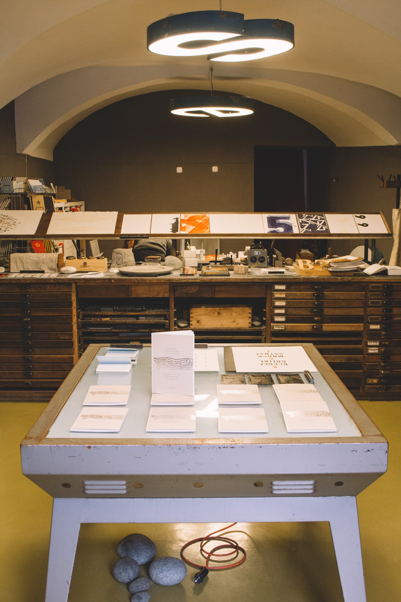 Interior of TipoRenesansa letterpress studio showing vintage printing equipment and wooden drawers.