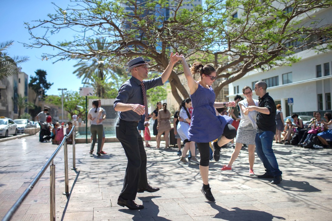 Members of Holy Lindy Land swing-dance troupe perform in a sunny public plaza in Tel Aviv.