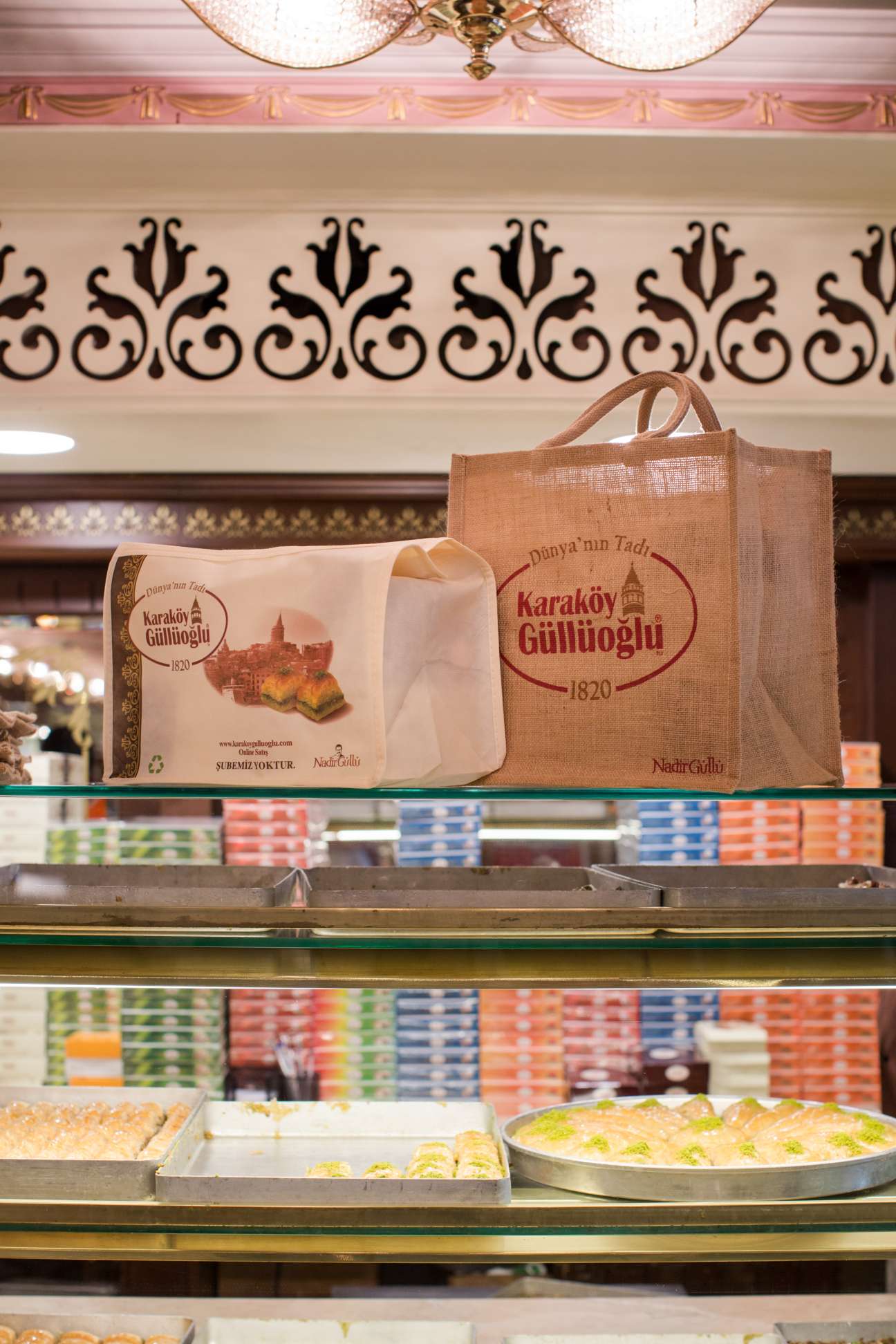 Karakoy Gulluoglu baklava packaging and products displayed in an ornate Istanbul shop window with decorative ceiling.