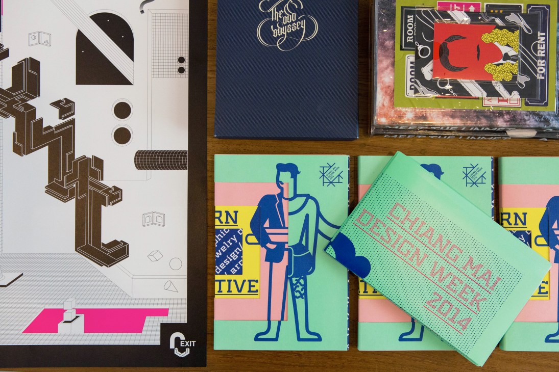 Colorful graphic design materials including notebooks and printed materials with modern typography and illustrations