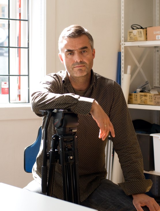 Tore Buvarp, a producer at Fenris Film, poses with professional video camera equipment in an office.