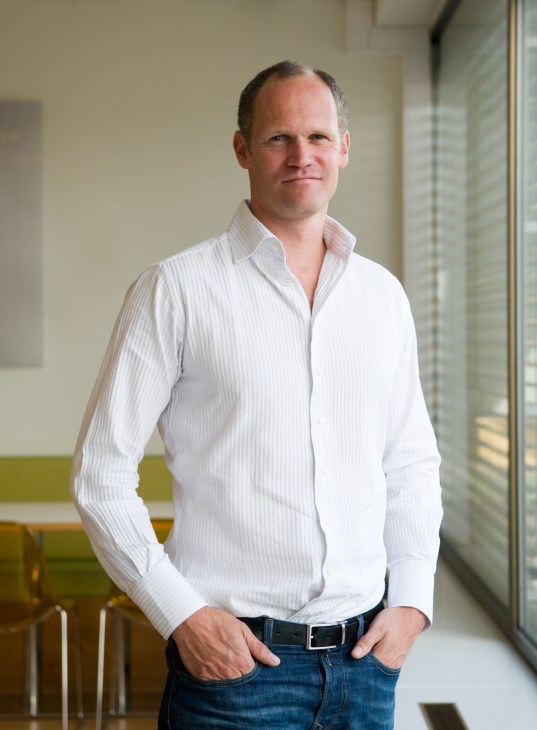 Mats Ektvedt, editor at Dokument 2, stands in a modern office corridor wearing a white striped shirt.