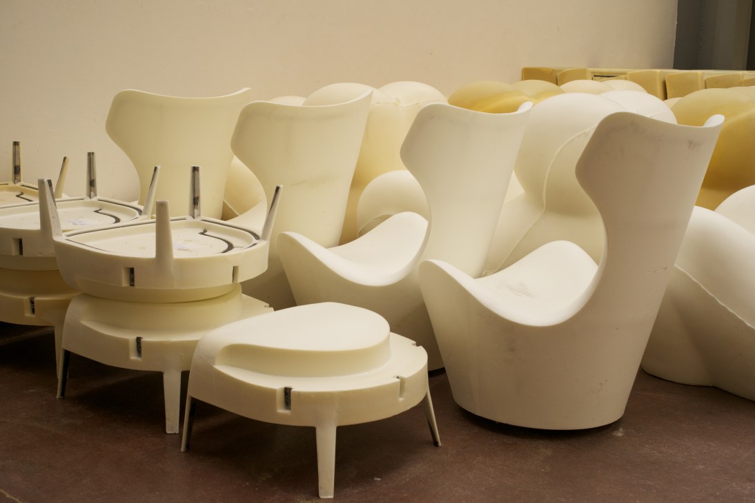 Cream-coloured polyurethane foam chair and sofa pieces with metal support rods after moulding and trimming.