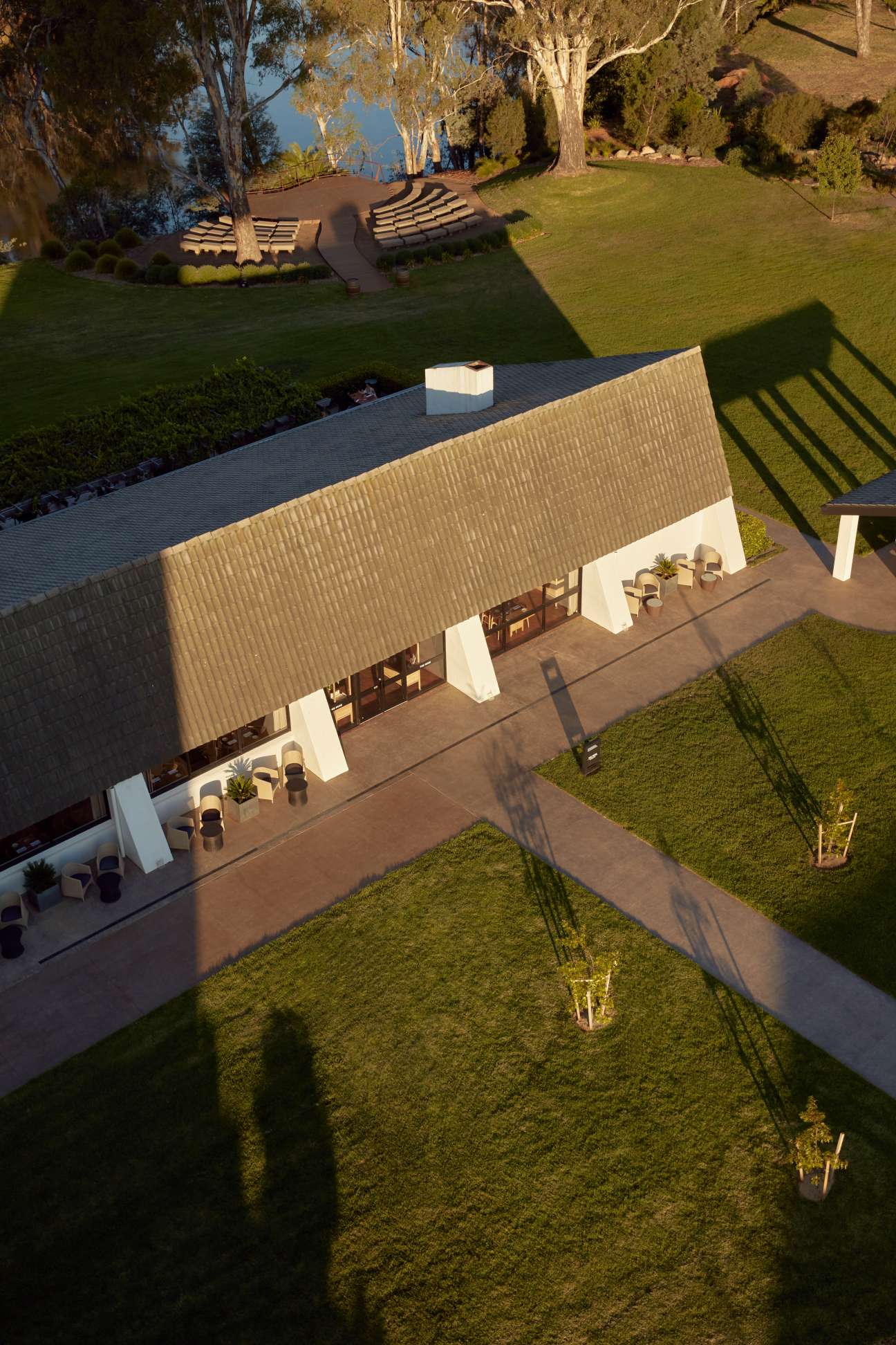 Aerial view of Mitchelton Wines' new hotel with corrugated roof overlooking manicured lawns and vineyard grounds.