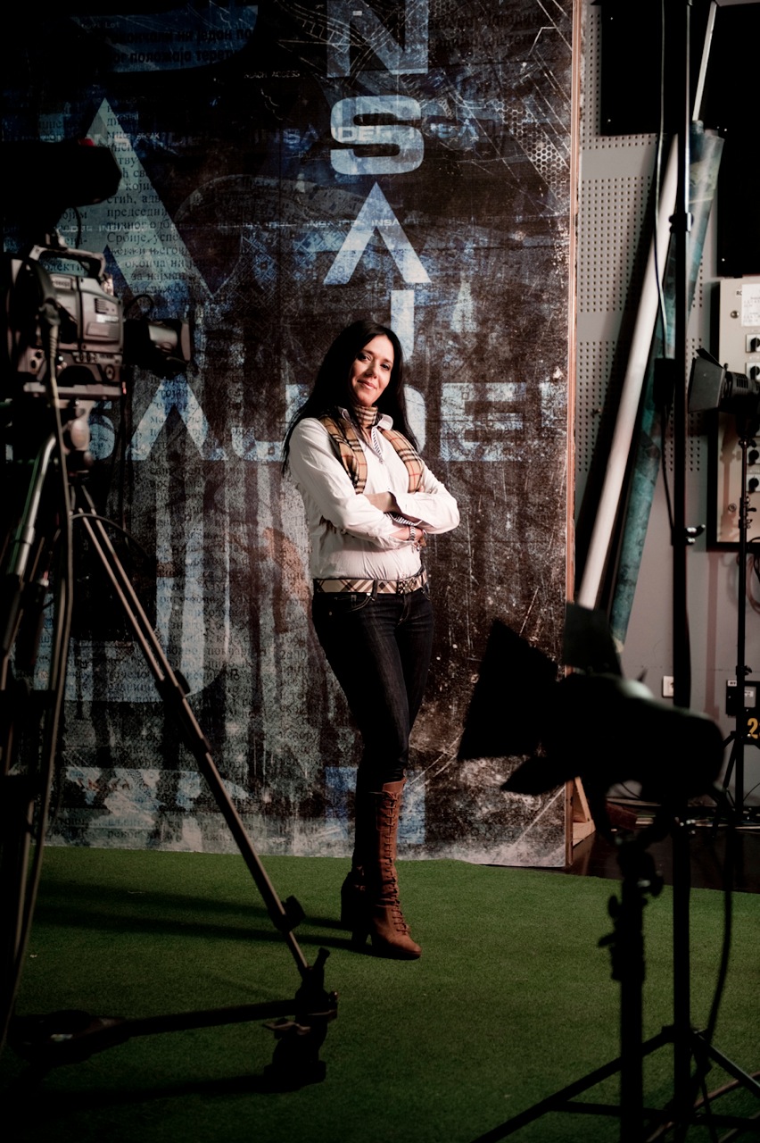 Brankica Stankovic stands with arms crossed on the Insajder set, with camera equipment visible beside her.