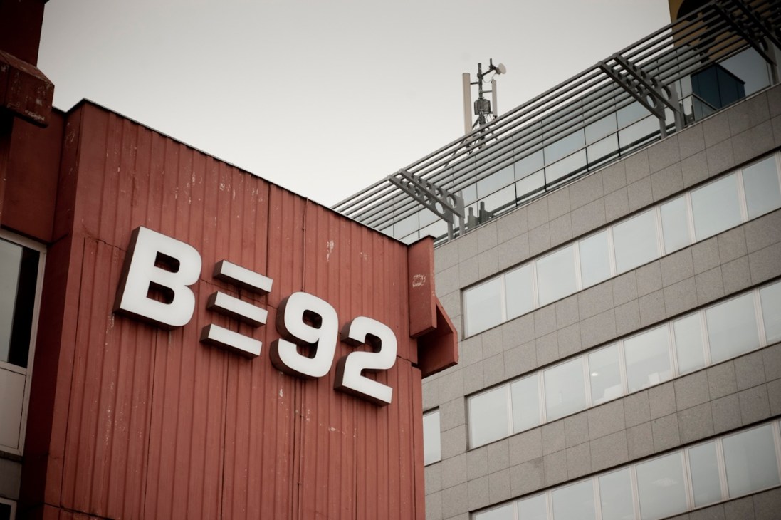 B92 radio and television station building exterior with red corrugated metal wall and white logo sign in downtown Belgrade.