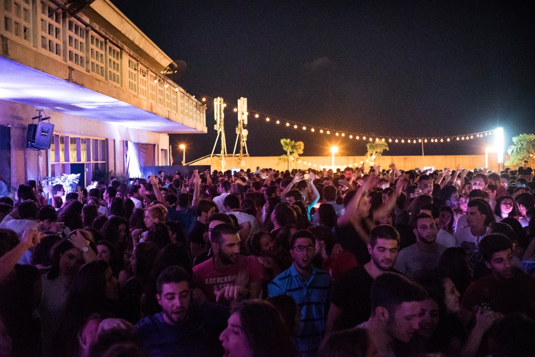 Crowded dance floor at St Georges Hotel nightclub in Beirut with purple lighting and many people dancing.