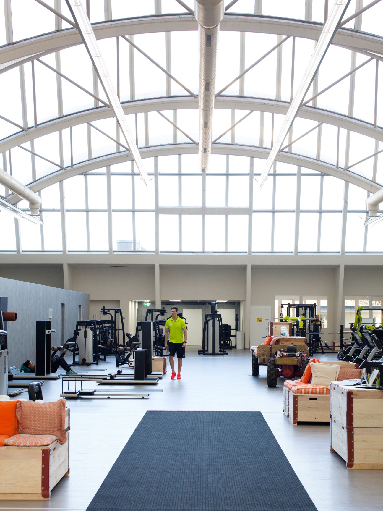 Interior of Update Fitness gym in Gossau showing exercise equipment under a distinctive rippling roof with curved windows.