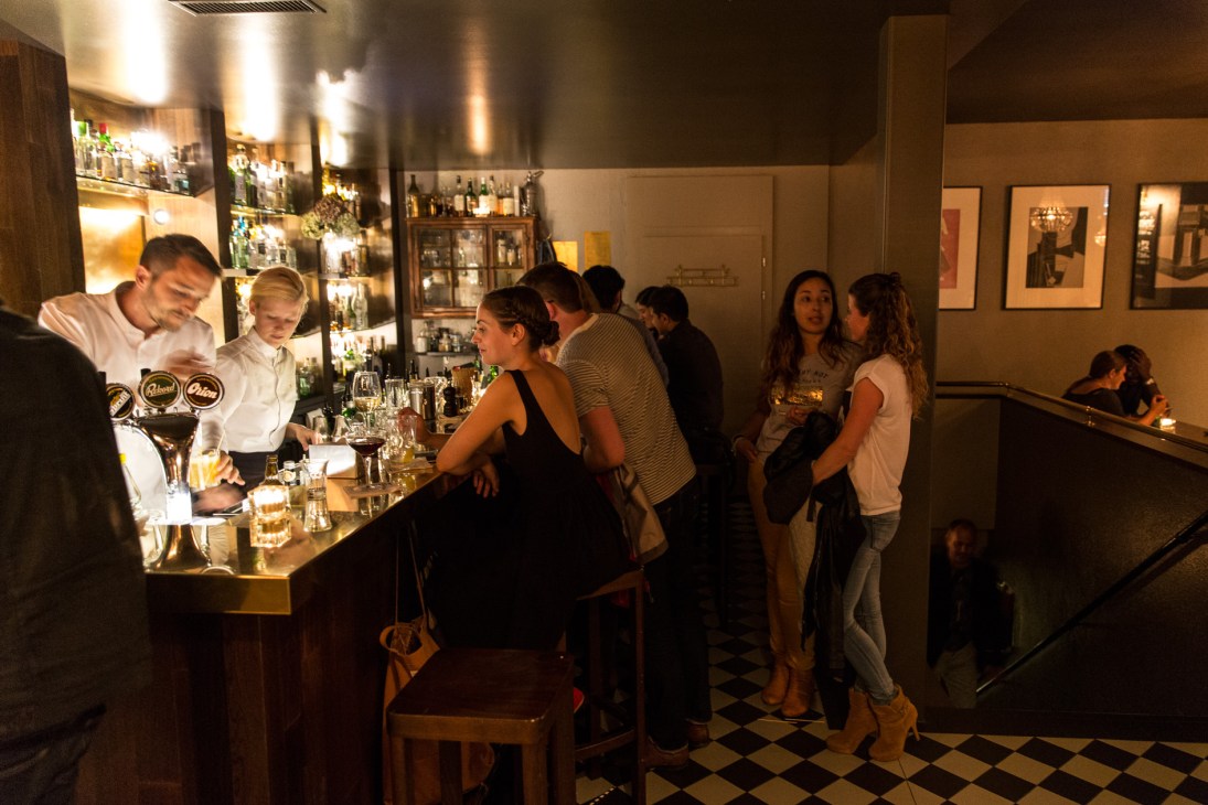 Bartender serving drinks to customers at Dante cocktail bar in Zürich's Kreis 4 district.