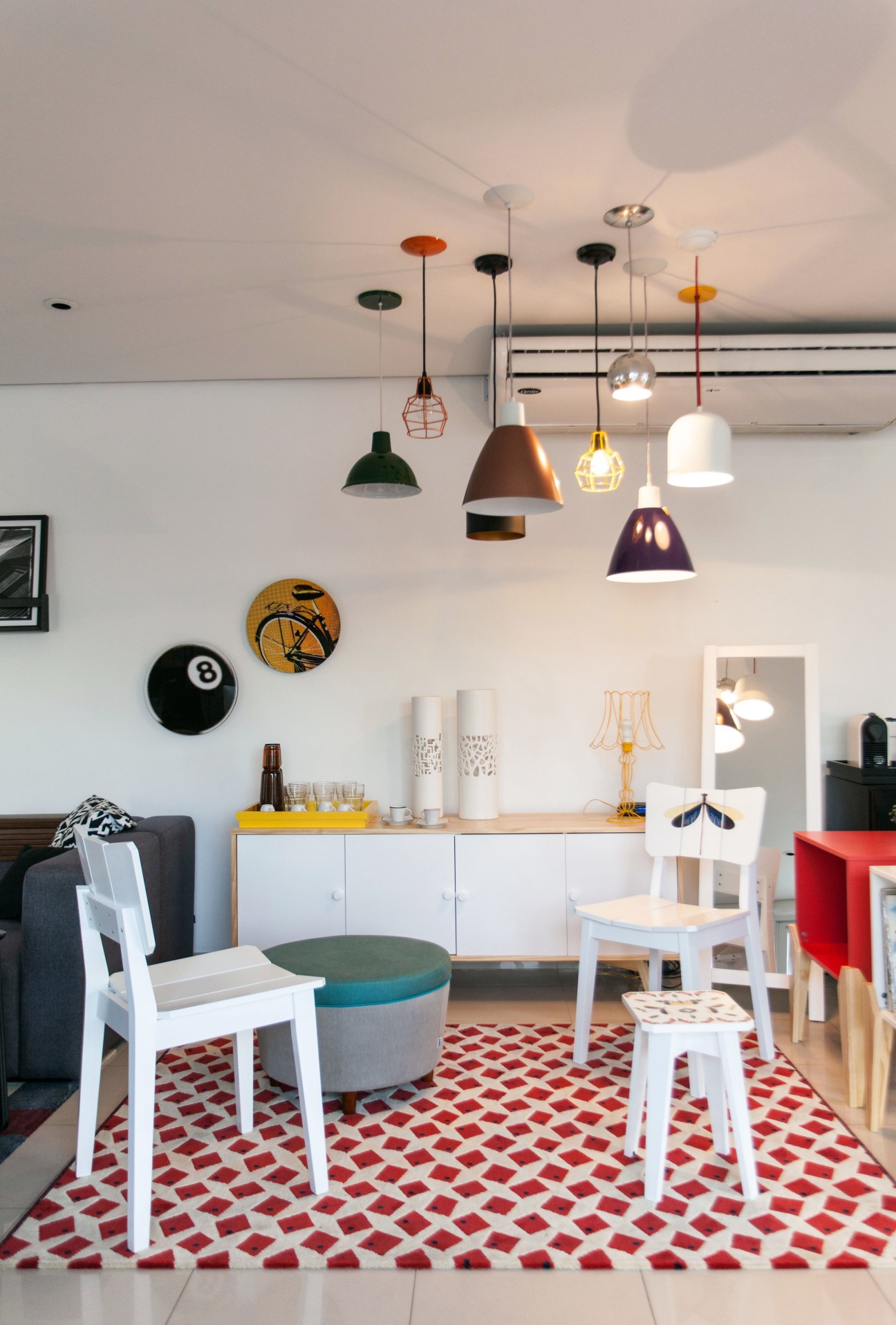 Interior of Oppa Design store with colorful pendant lights, white chairs, and modern furnishings.
