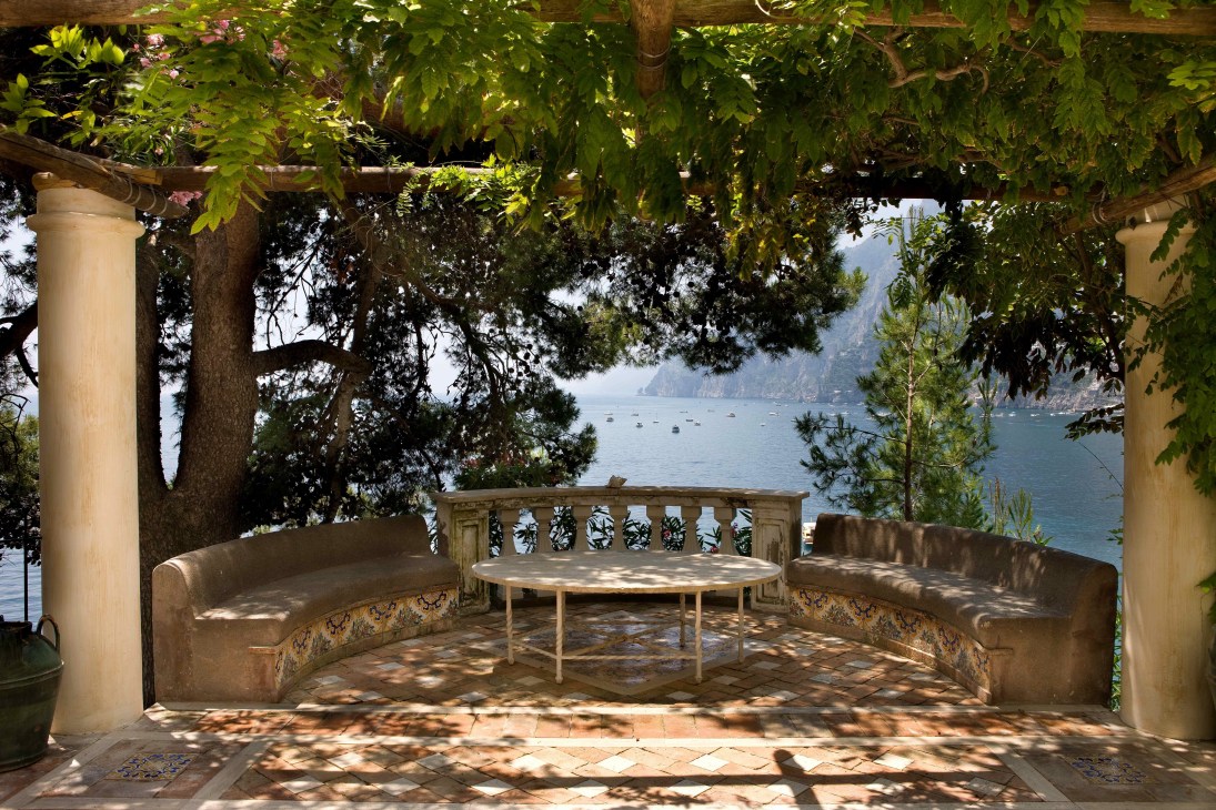 Pergola-shaded terrace at Villa Tre Ville overlooking the Amalfi Coast with built-in seating and coastal views.
