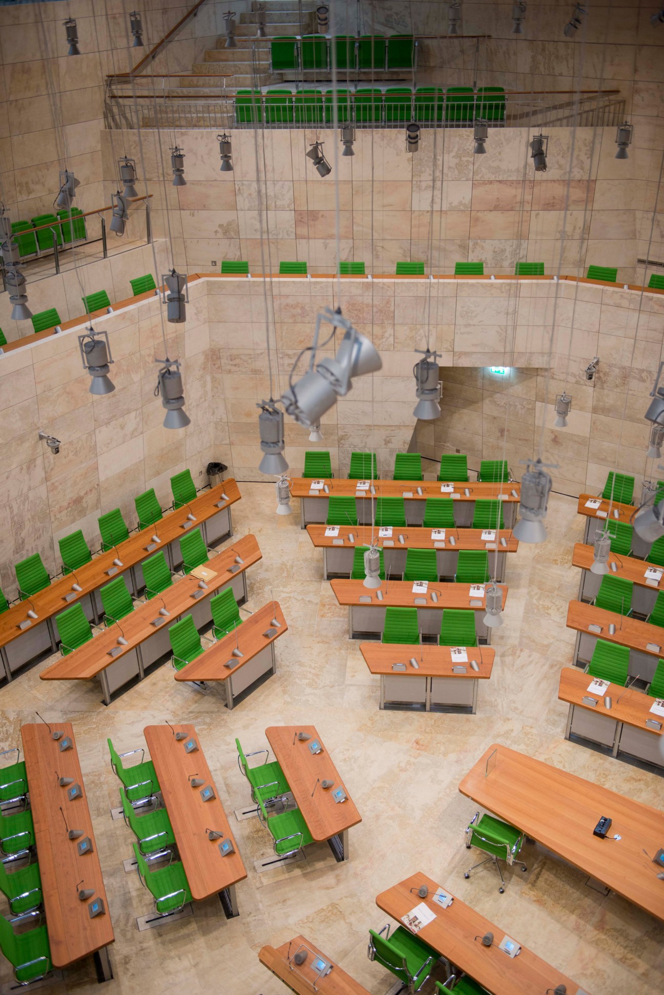 Aerial view of Parliament House's plenary chamber with green chairs and orange desks arranged in rows.