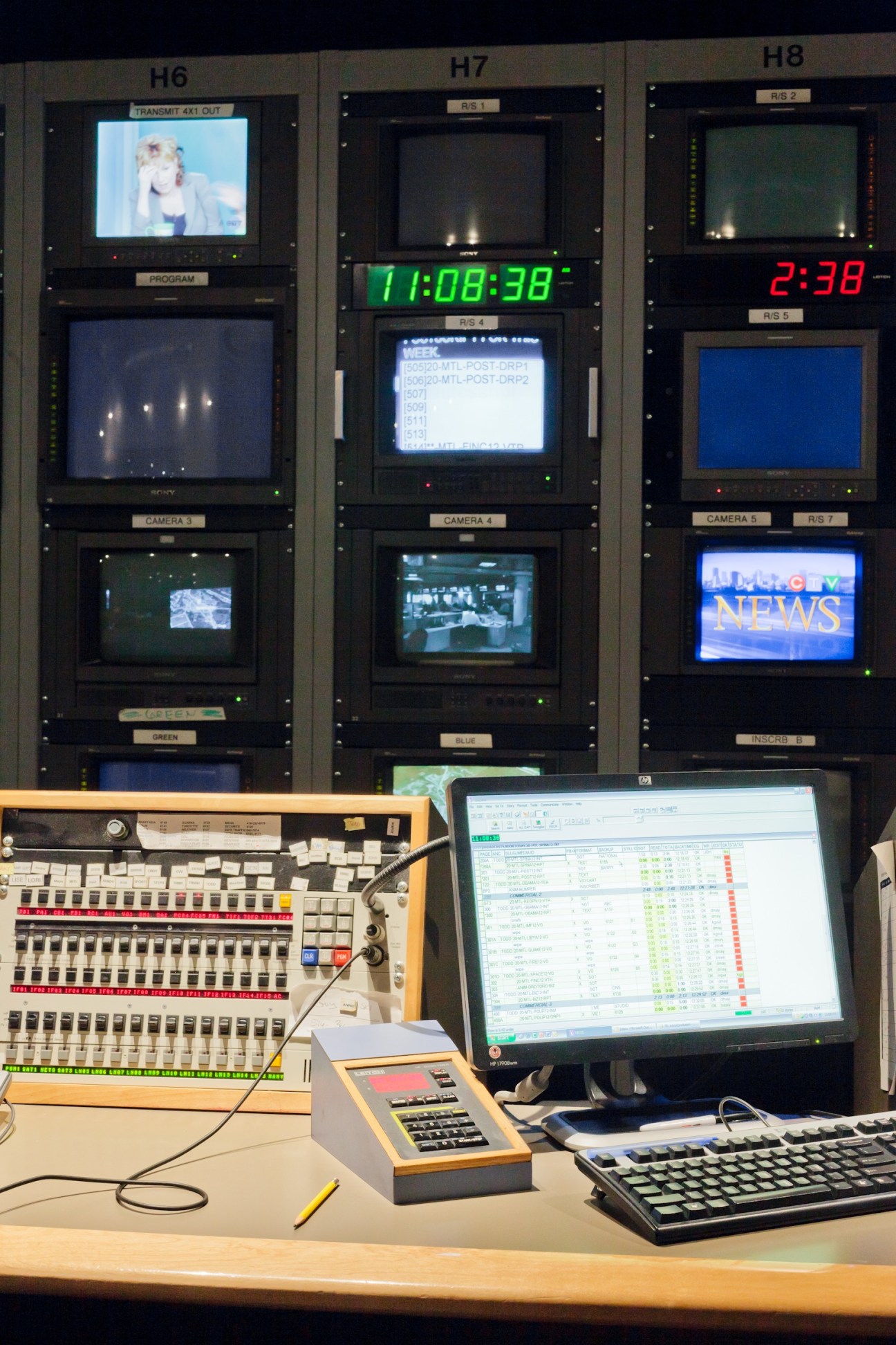 Television studio control room with multiple monitors, timecode displays, and broadcast equipment.