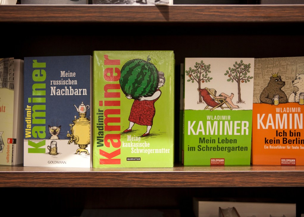 Wladimir Kaminer's books displayed on a wooden shelf in a Berlin bookstore.