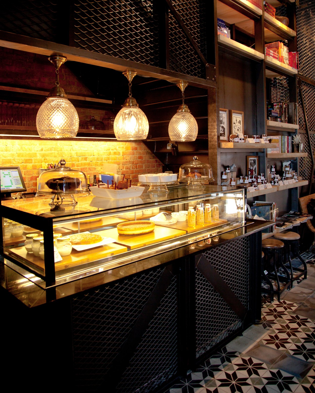 Interior of VVG Thinking shop with pendant lights, display cases, brick walls and shelving.