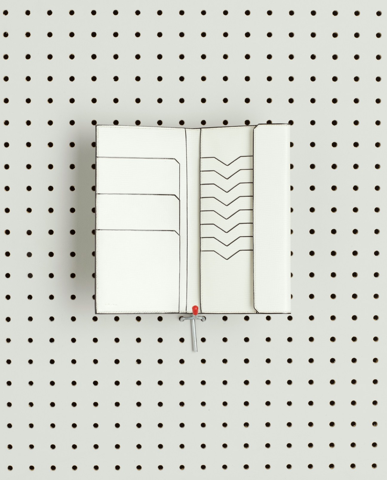 Leather wallet design displayed on pegboard with technical line drawings showing compartments and construction details.