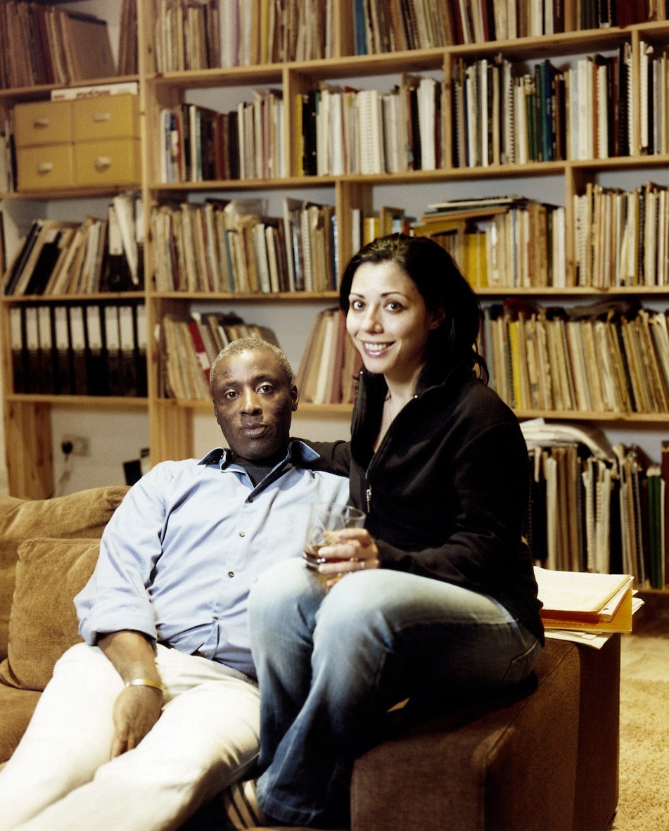 Pianist and conductor Wayne Marshall with his partner sitting in front of a bookshelf.
