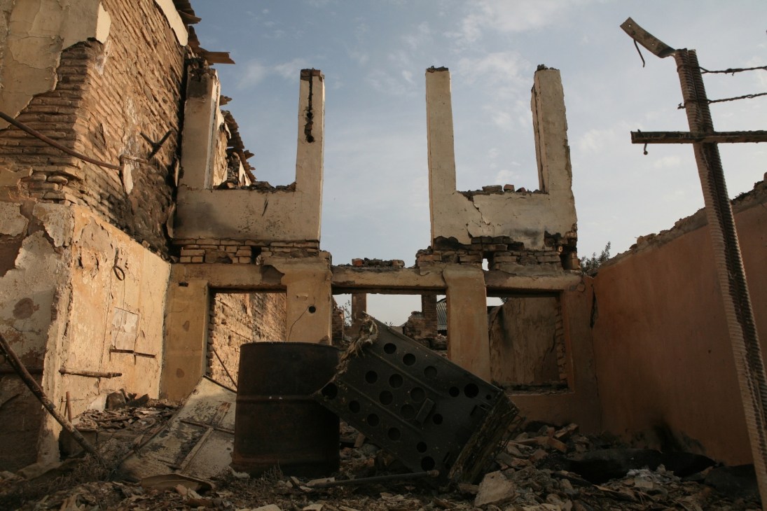 Ruins of a destroyed house in Tskhinvali with collapsed walls and exposed concrete pillars.