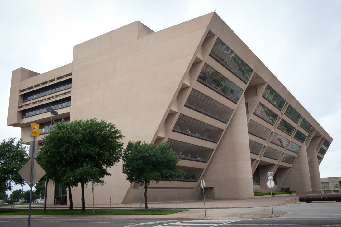 I.M. Pei's Dallas City Hall, a modernist concrete building with angular geometric forms and sloped facade.