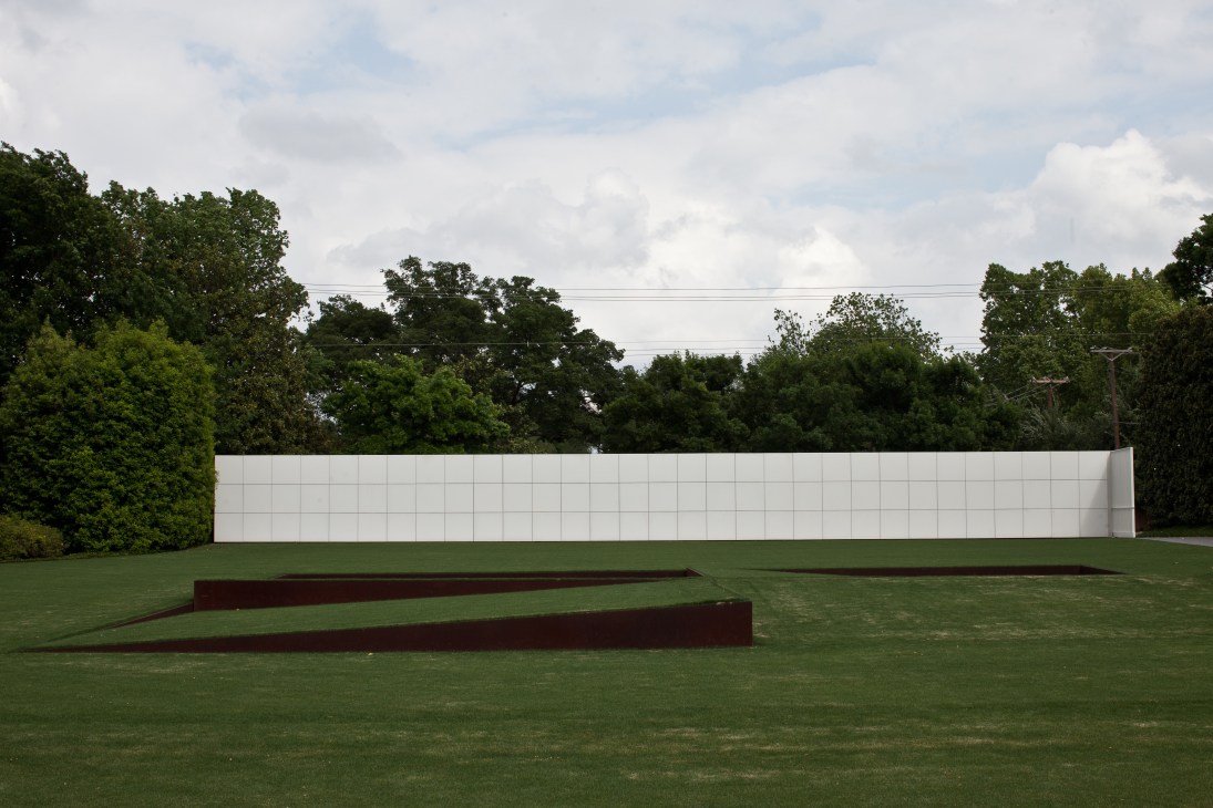 Robert Irwin's minimalist sculpture on the lawn of the Rachofsky House, featuring dark red geometric forms against a white wall.