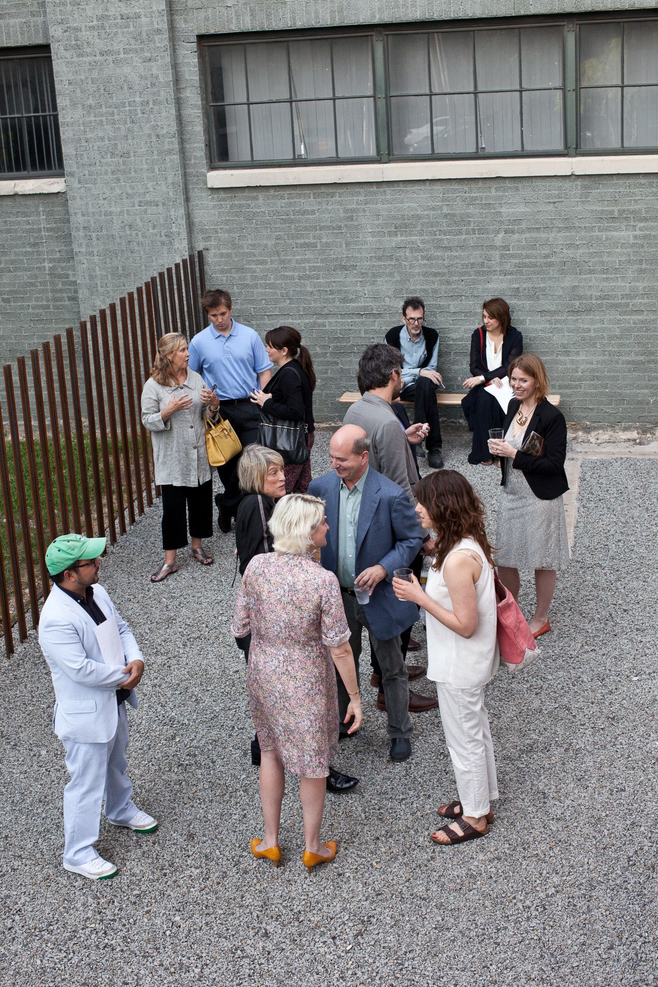 Guests arriving for the Jacob Kassay opening at The Power Station, standing in an outdoor courtyard area.