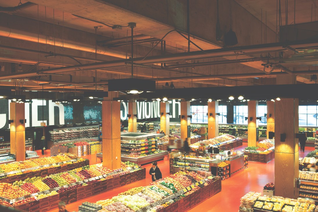 Interior of Loblaws grocery store at Maple Leaf Gardens showing produce displays with warm lighting and orange flooring.