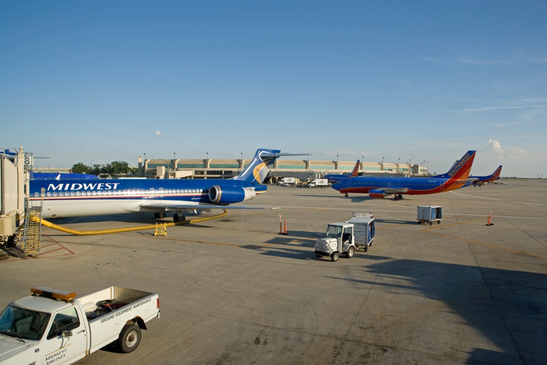 Midwest Airlines and Southwest Airlines planes parked at Kansas City International Airport terminal.