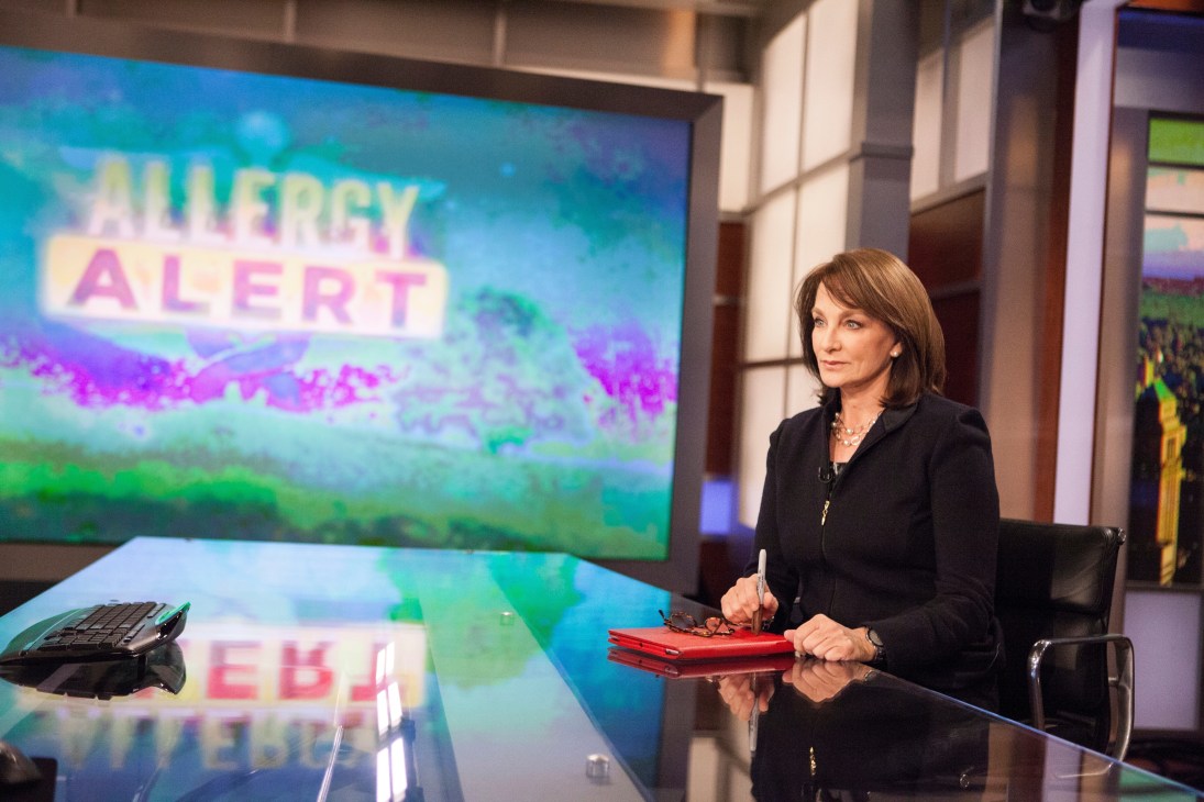 Nancy Snyderman sitting at a TV studio desk with an 'Allergy Alert' graphic displayed on the screen behind her.