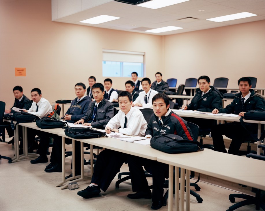 Chinese pilot trainees in formal uniforms sit at desks during a classroom lesson at Moncton Flight College.