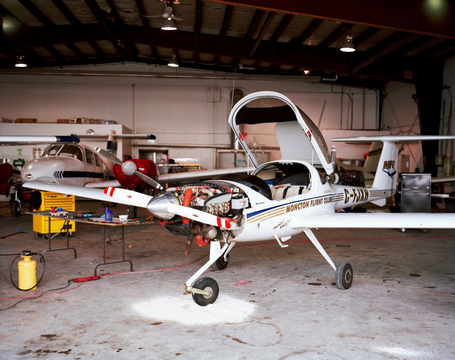 A Cessna training aircraft undergoing maintenance in Moncton Flight College's hangar.