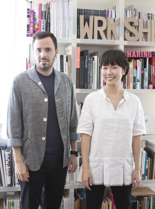 Airi Isoda and Ryan Upton of wrk-shp stand in front of shelves of books and design materials.