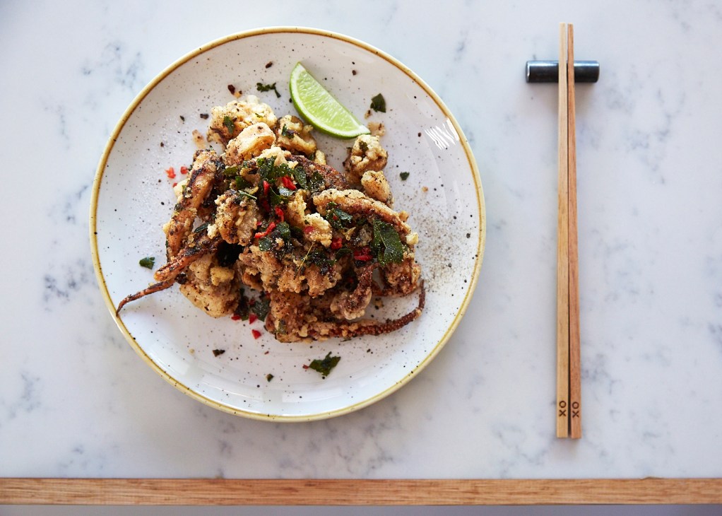 Plated fried soft-shell crab dish with lime wedge and herbs at XO restaurant in Canberra.