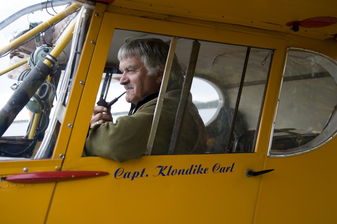 Carl Clouter sits in the cockpit of his yellow seaplane named Capt. Klondike Carl.