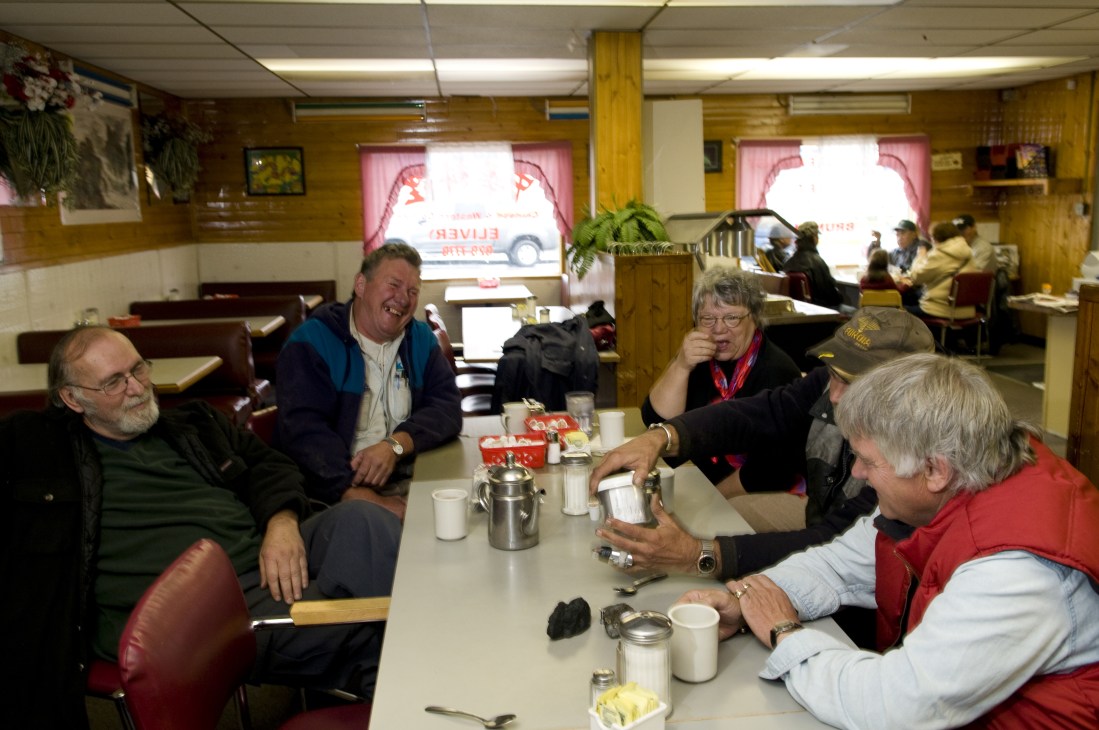 Prospectors gather around a table at the Gold Range Café in Yellowknife, sharing coffee and conversation.