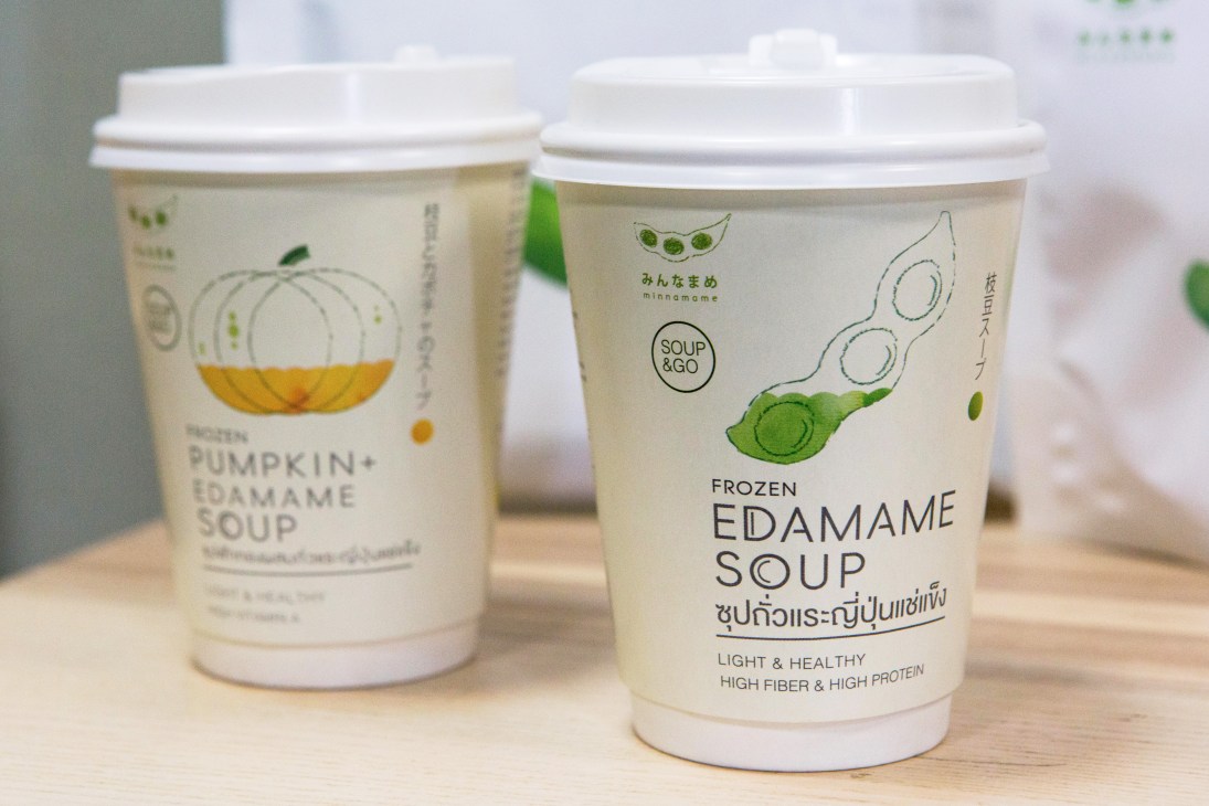 Two takeaway soup containers with minimalist design featuring pumpkin and edamame illustrations