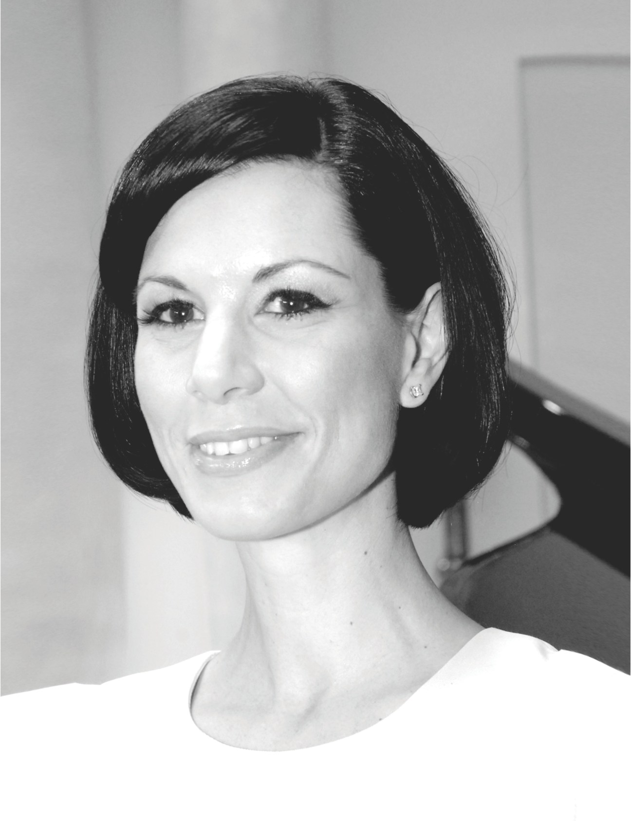 Black and white portrait photograph of Julia Stoschek, a woman with short dark hair smiling at the camera.