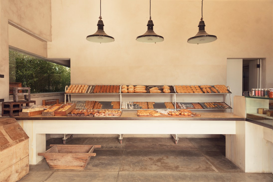 Interior of La Linda bakery displaying various pastries in tiered display cases under pendant lights.