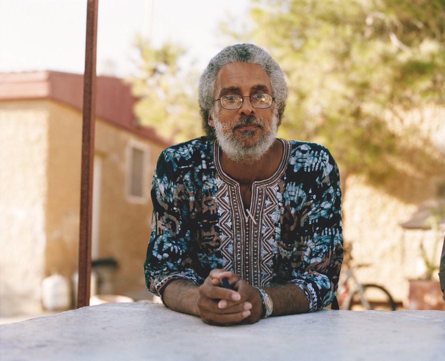 Ahmadiel Ben Yehuda, minister of the African Hebrew Israelites of Jerusalem, sitting at a table outdoors.