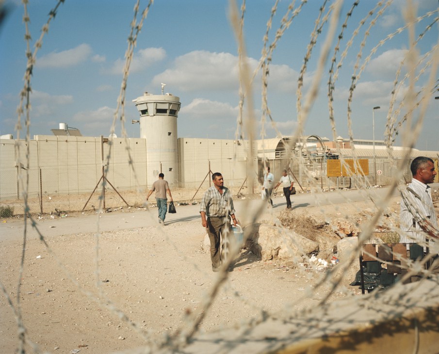 Palestinian workers walk through a checkpoint in the separation wall barrier dividing the West Bank from Israel.