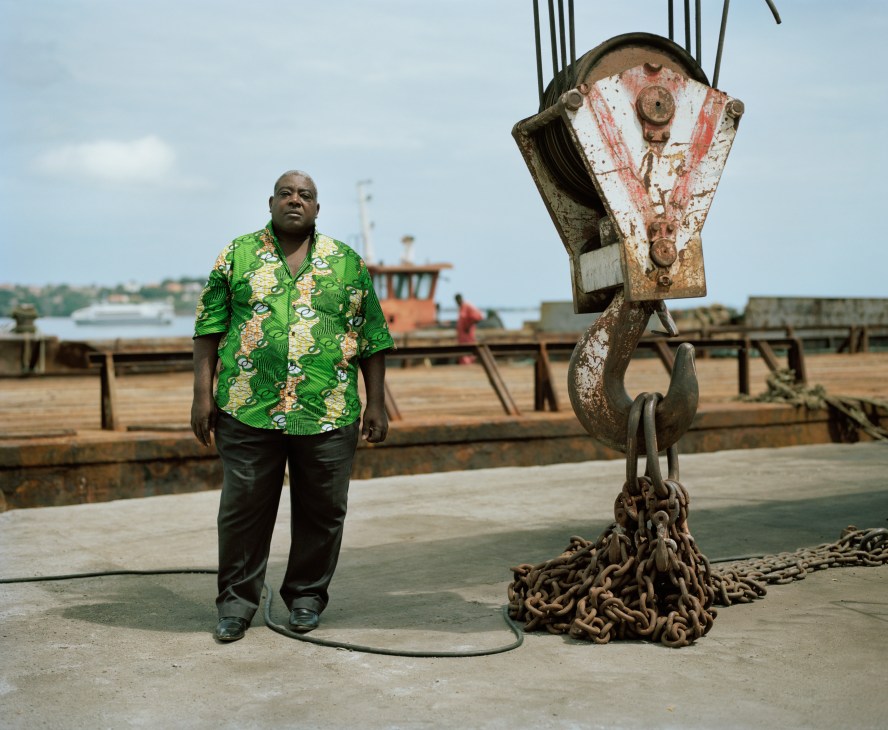 Adriano Rosamonte, technical director of São Tomé's port, stands beside a large rusted ship hook at the port.