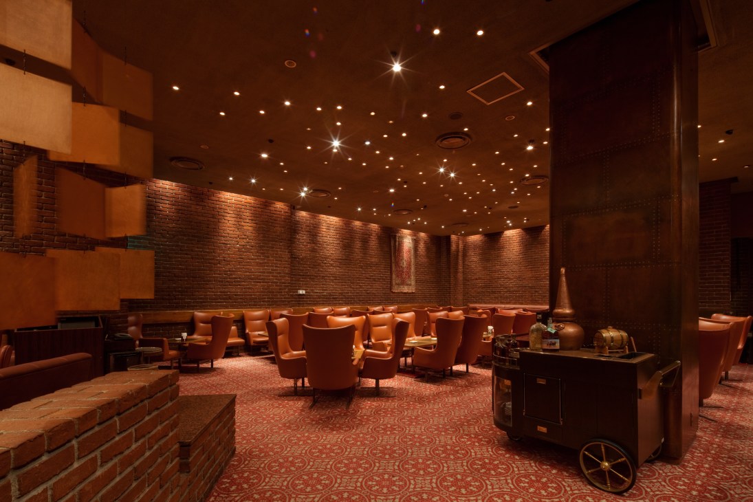 Brillant bar interior with warm lighting, orange leather chairs, brick walls and retro design at Keio Plaza Hotel.
